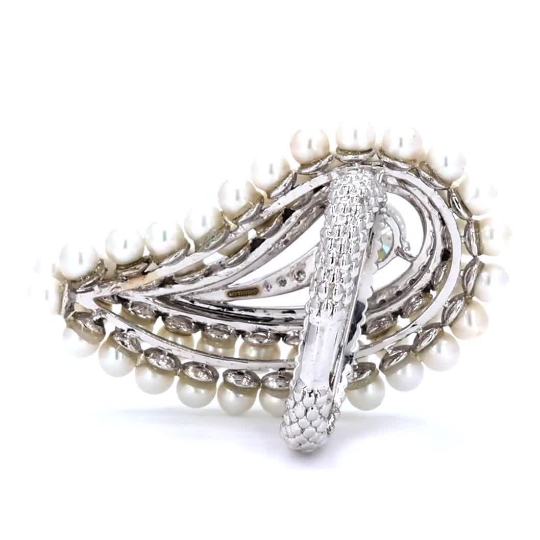 Held in hand showing the scale of the pearl and diamond cluster ring in 14K white gold