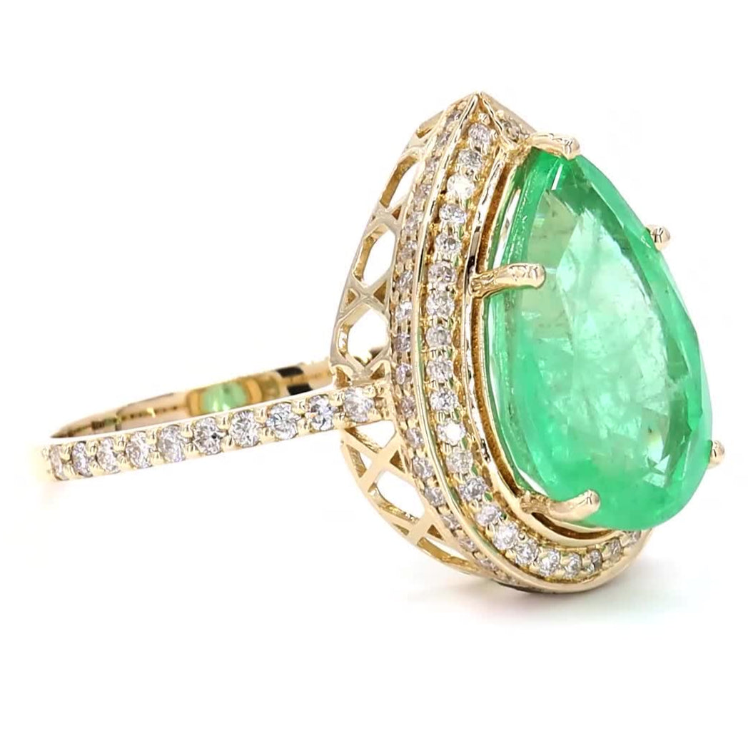 Worn on the hand — 14K yellow gold ring with a pear-shaped natural emerald in a diamond halo
