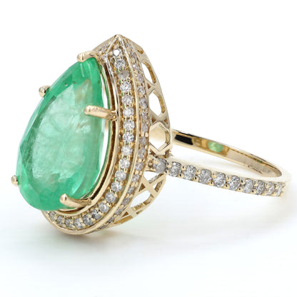Close-up of the diamond halo — 14K yellow gold ring framing a pear-cut natural emerald