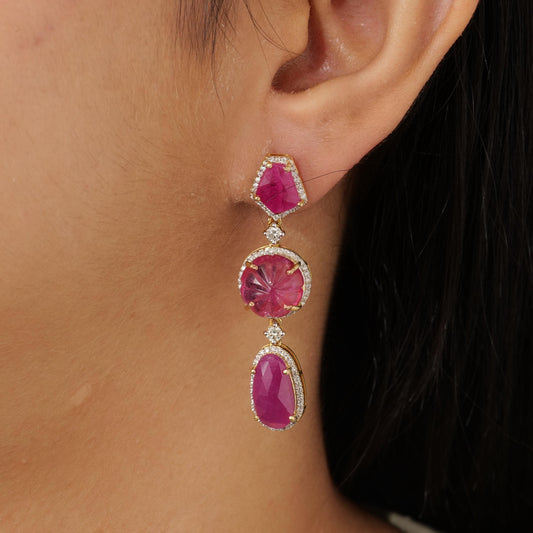 Natural ruby and rubellite drop earrings in 14K yellow gold, seen from the side.